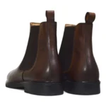We present the Brown Daniele Chelsea Boot from a 3/4 rear angle with pull-tab and leather detailing