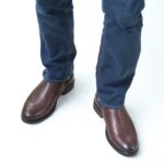 A model wearing Vittorio Wingtip Chelsea brown boots showing front view, broguing and wingtip design